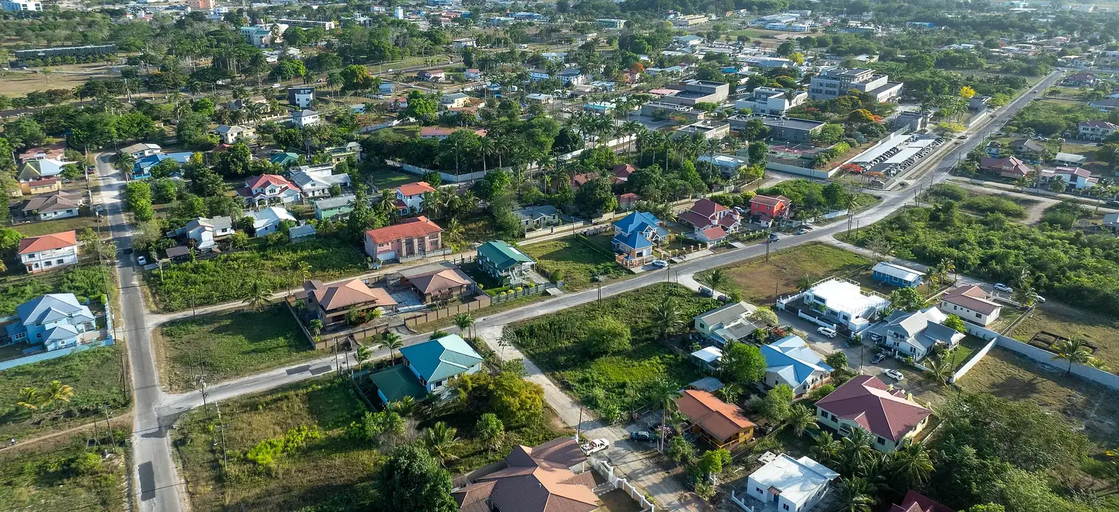 Aerial view of homes and tree-lined streets in a residential neighborhood of Belmopan, Belize