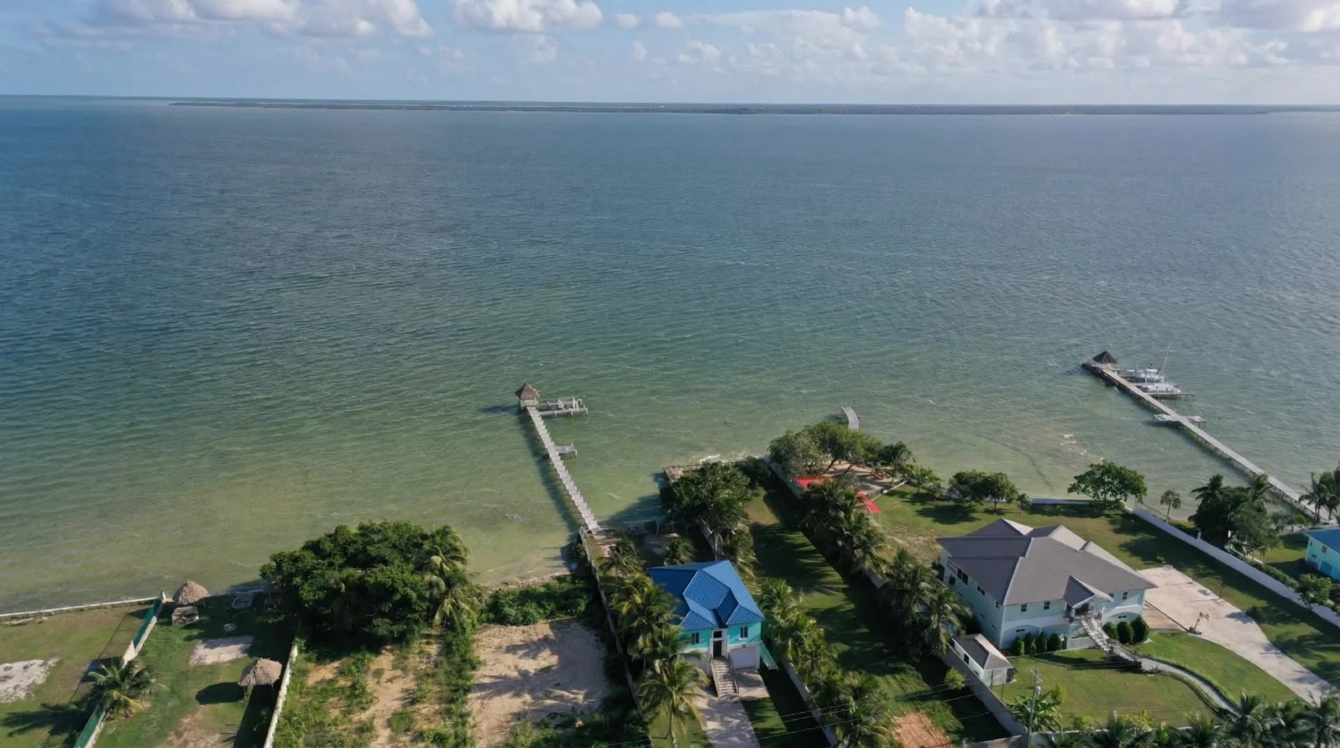 Aerial view of Corozal Bay waterfront homes and piers, northern Belize — property for sale