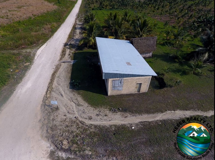 Large concrete warehouse on a 24.42-acre coconut and lime farm near Spanish Lookout, Belize.