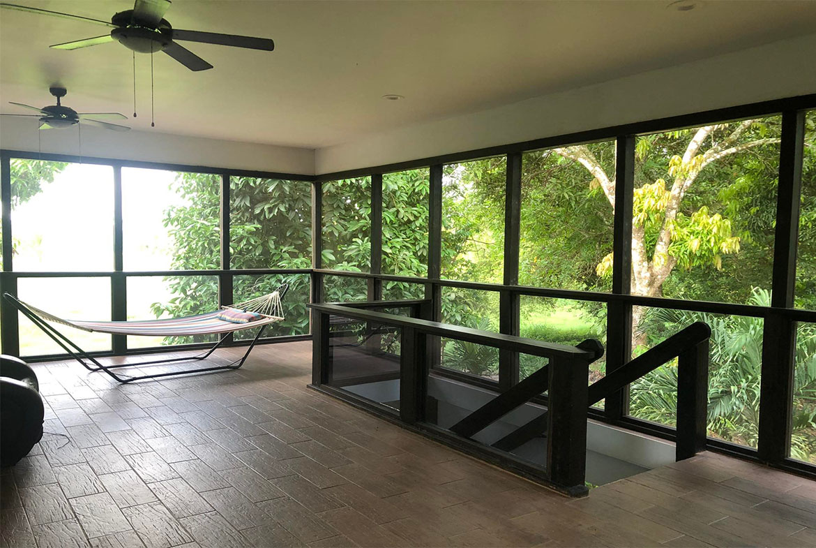 Covered porch with comfortable seating and mosquito netting.