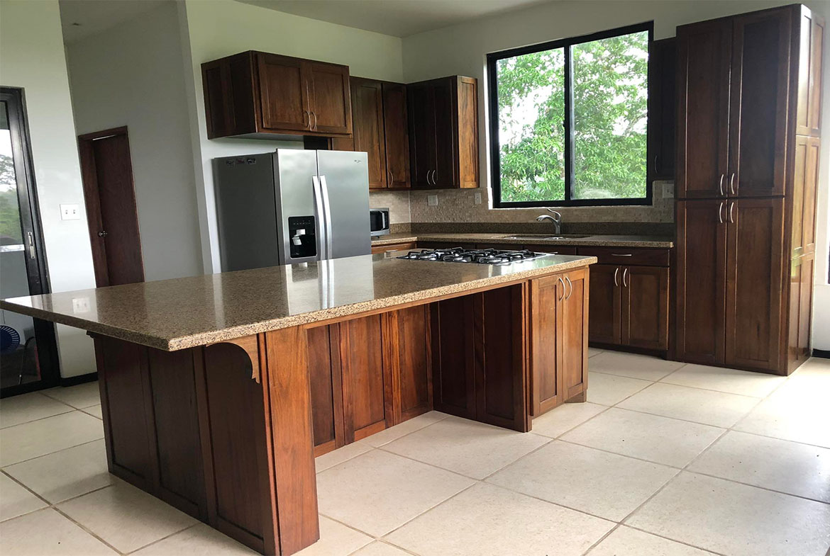 Modern kitchen with stainless steel appliances and wooden cabinets.