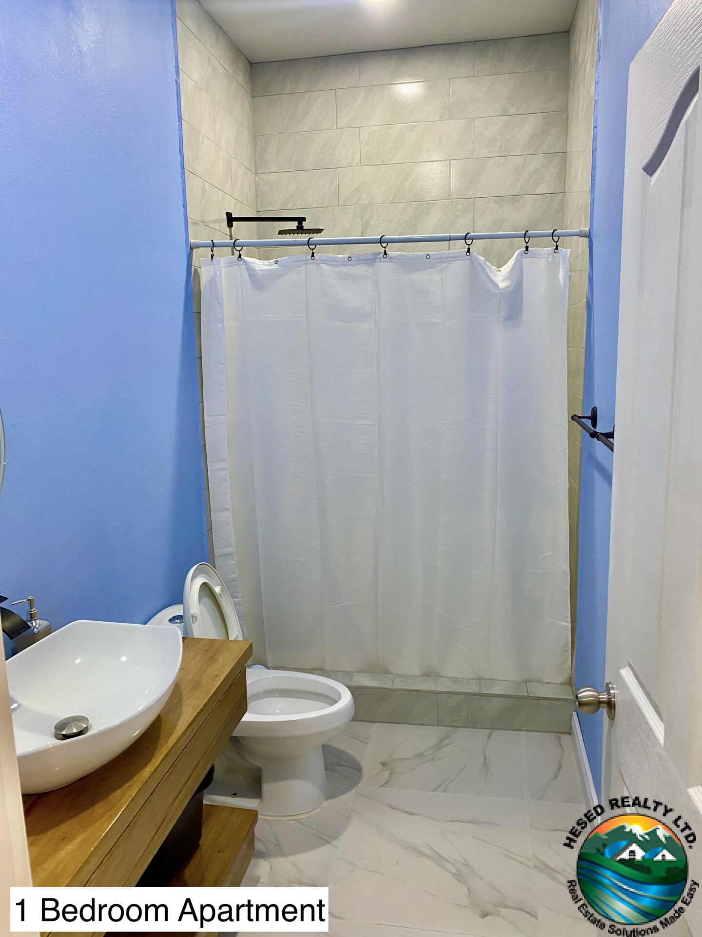 Modern bathroom in a 1-bedroom apartment with sleek fixtures, ample lighting, and functional storage.