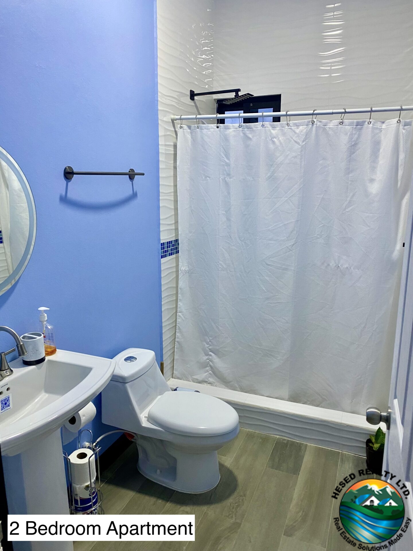 Modern bathroom in a 2-bedroom apartment featuring sleek fixtures, ample lighting, and functional storage solutions.