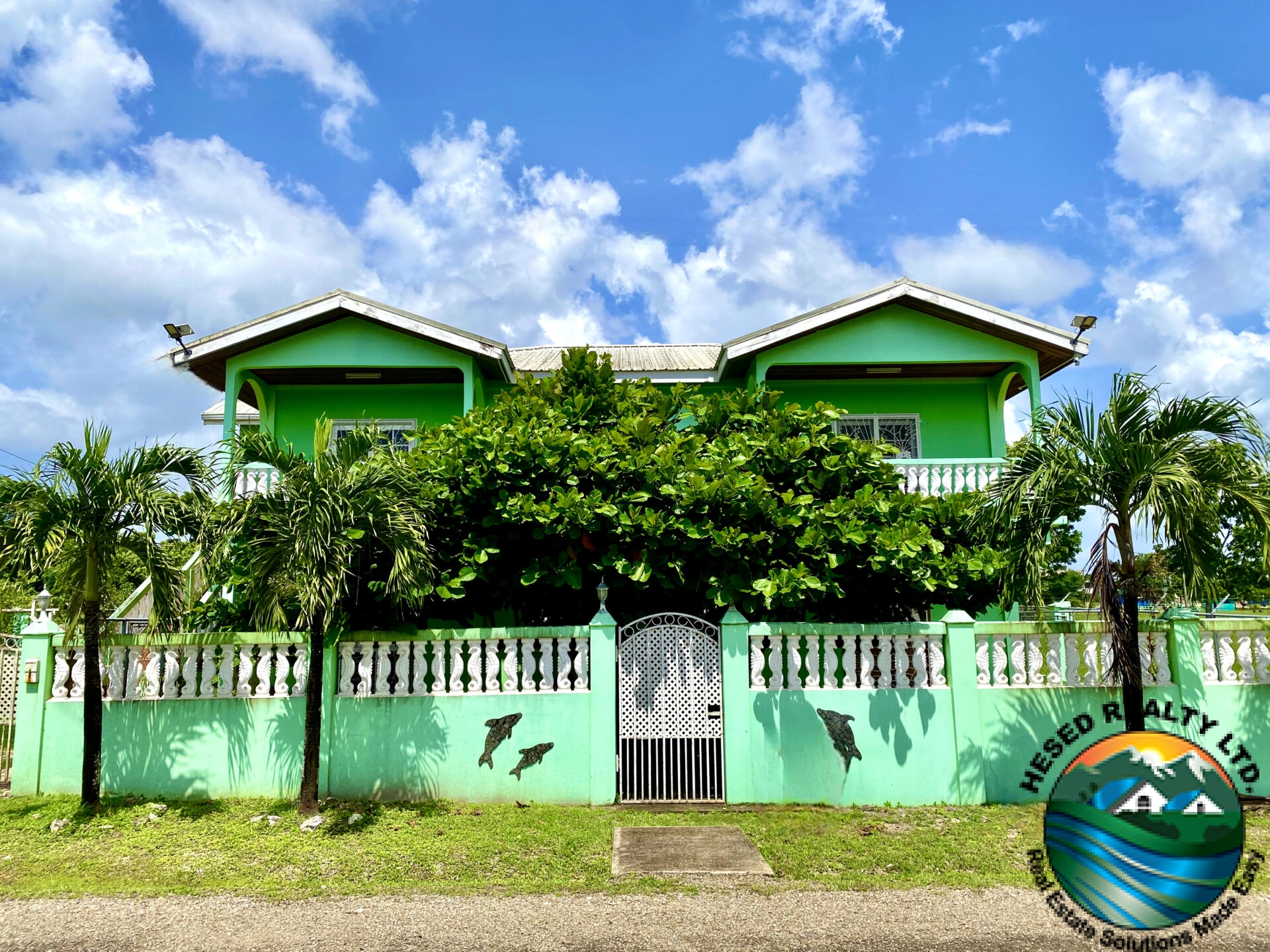 Front view of 1-bedroom apartment in Belmopan with a secured entry and surrounding yard.