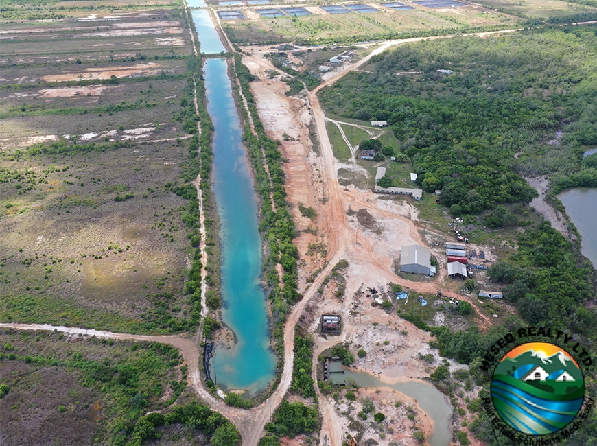 A canal flowing next to a house at Aqua Mar, part of the extensive water infrastructure supporting agricultural operations