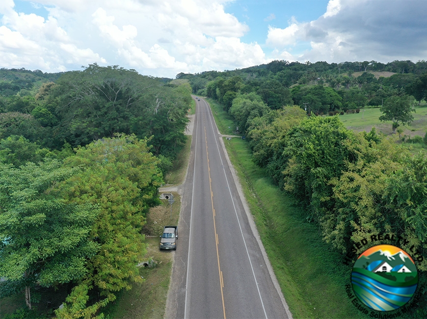 Aerial view of the George Price Highway lined with trees, illustrating the scenic backdrop near the 118-acre property.