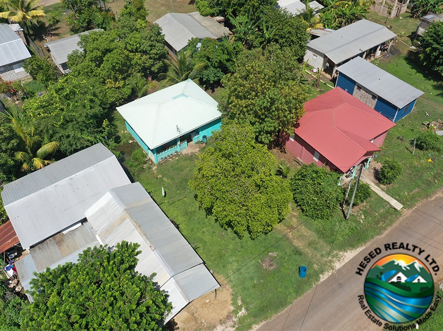 Aerial view of 2-bedroom family home in Belmopan, Belize, showcasing the property’s spacious yard and greenery.