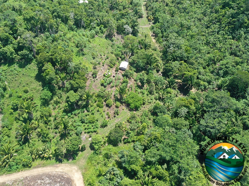 A zoomed-out drone photo of the entrance and surrounding area of a 3-acre property in Agua Viva.