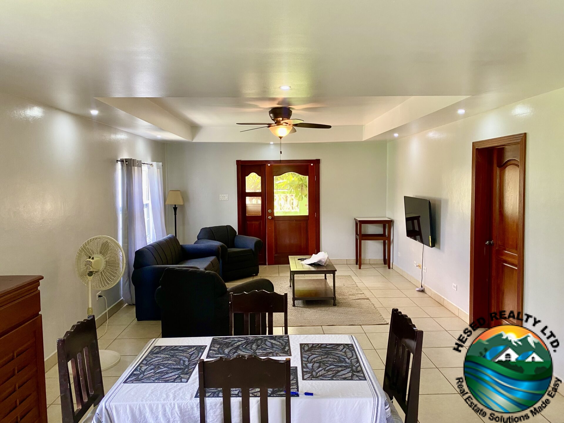 Open-concept living room in Belmopan apartment with natural light and spacious layout.