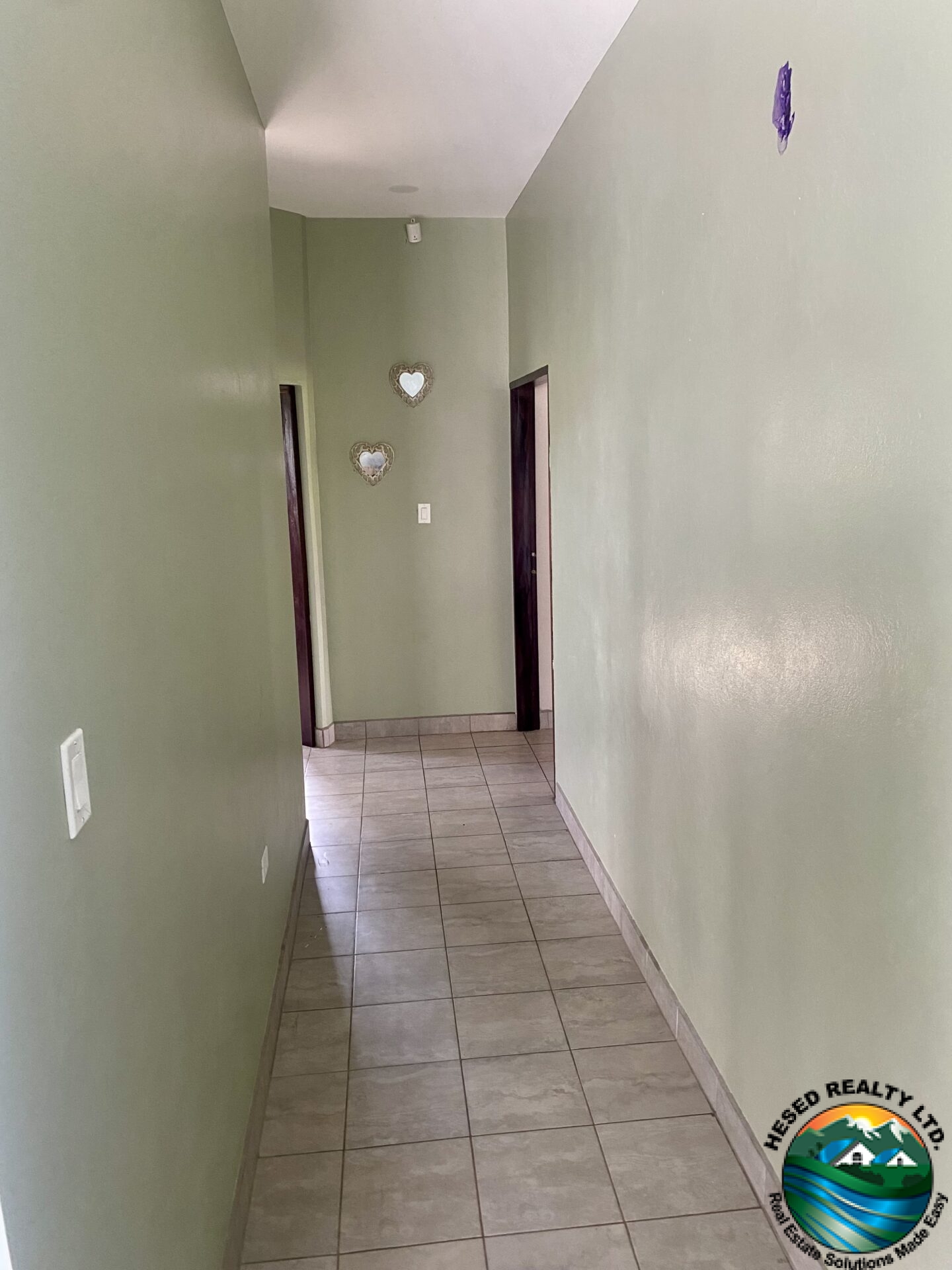 Bright upstairs hallway with tile floors.