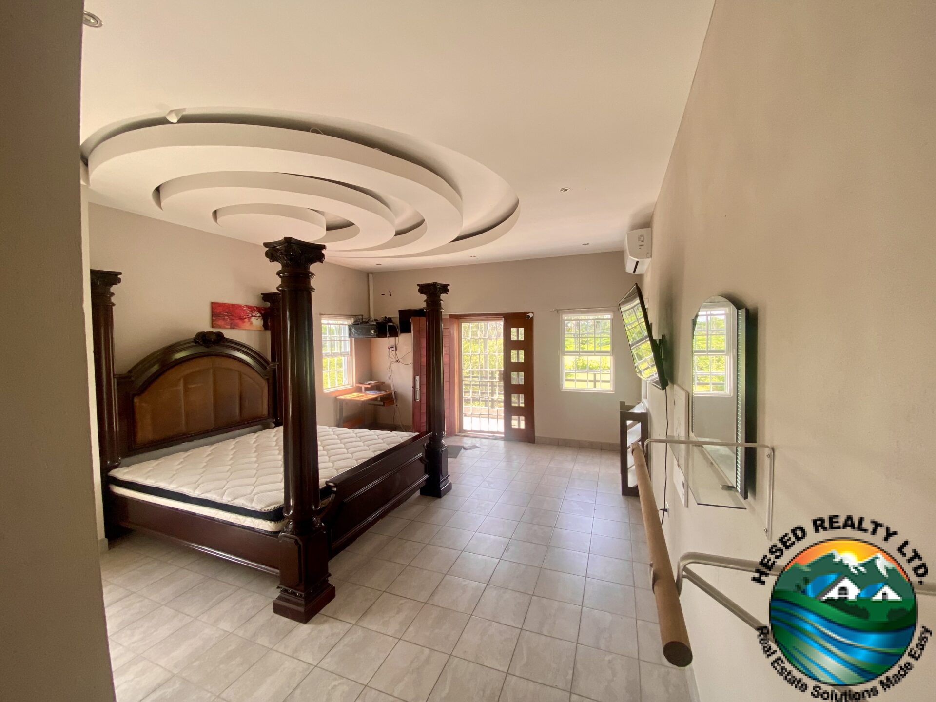 Luxurious master bedroom with large bed, elegant decor, and ample natural light.