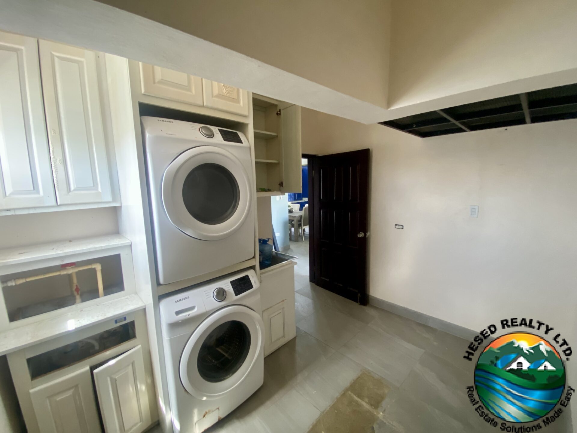 : "Functional laundry room with modern washer and dryer, storage cabinets, and ample workspace."