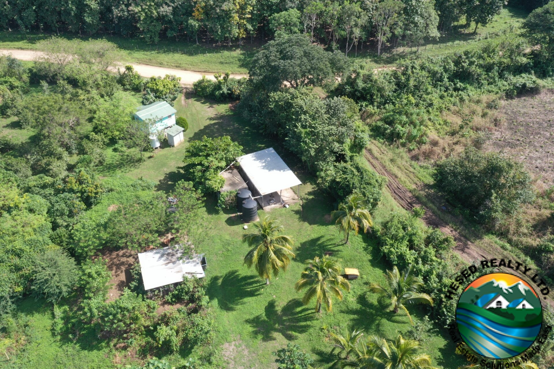 Drone shot capturing three buildings on the property from above.